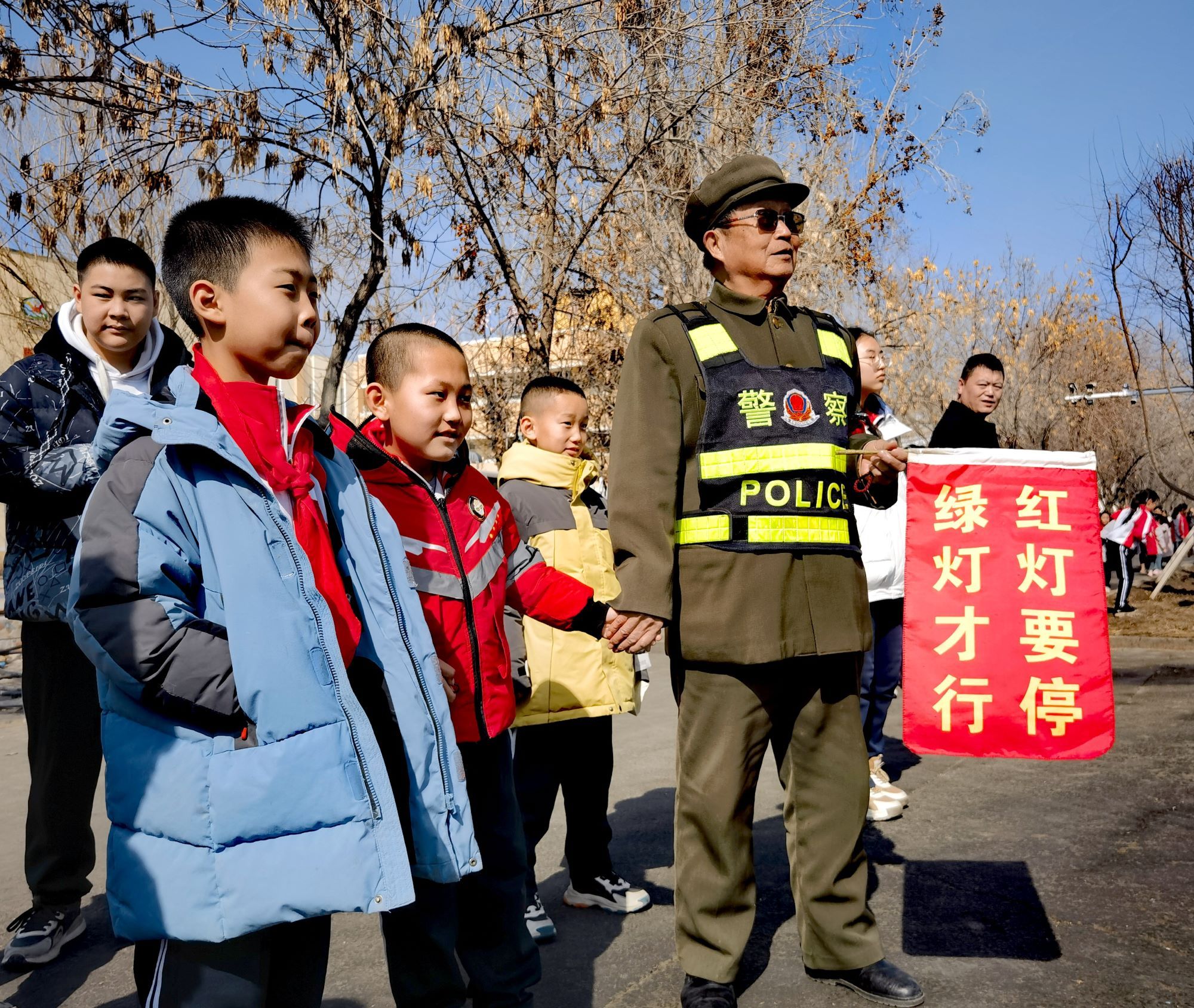 郑志义在五家渠一小路口护送小学生上学。张琳琳 摄